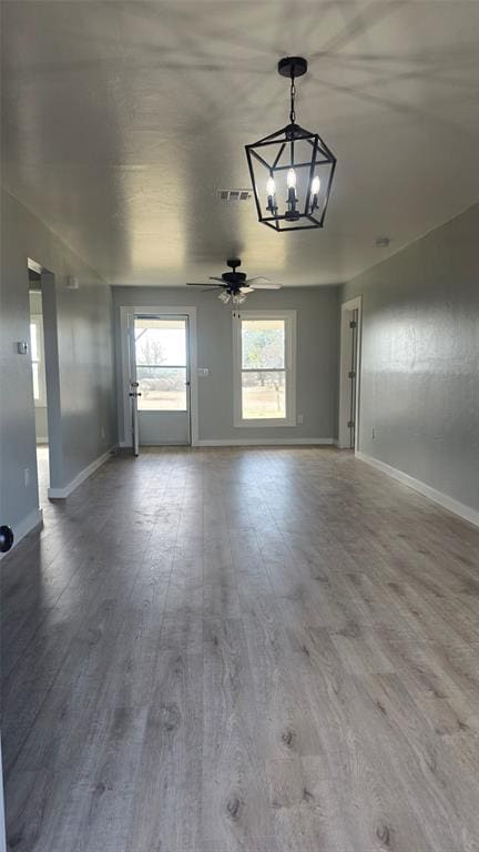 interior space featuring wood-type flooring and ceiling fan with notable chandelier