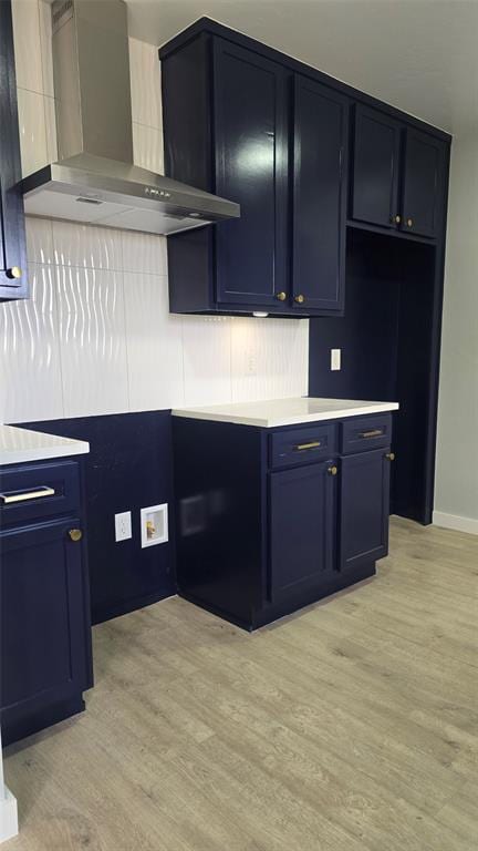 kitchen with wall chimney range hood and light hardwood / wood-style floors