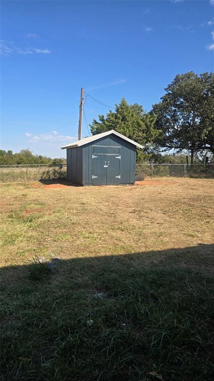 view of yard featuring a rural view and a storage unit