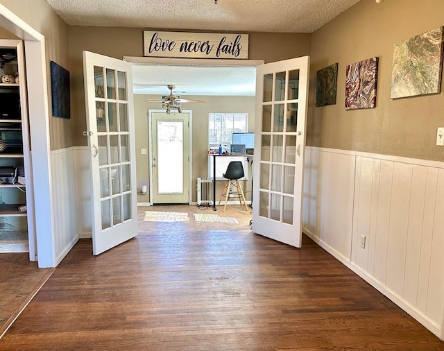 foyer entrance featuring french doors, a textured ceiling, and wood finished floors