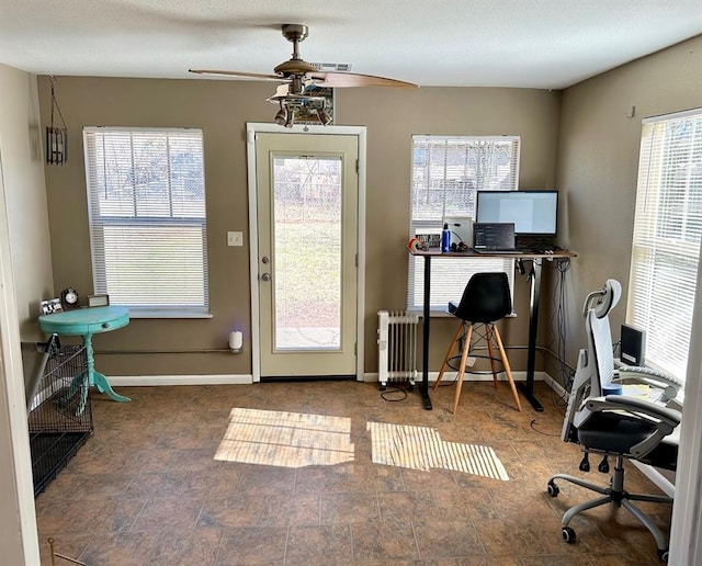 home office featuring radiator, a ceiling fan, and baseboards