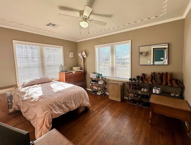 bedroom with visible vents, a ceiling fan, wood finished floors, crown molding, and baseboards