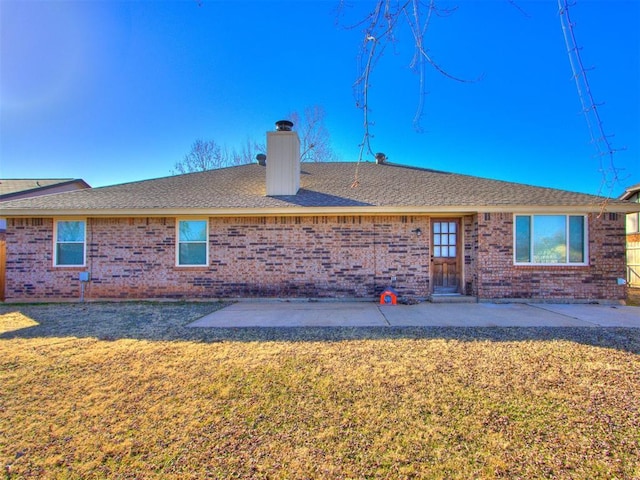 720 Cottonwood Dr, Moore, OK 73160 - back of property with brick siding, a yard, a chimney, a patio area, and a shingled roof