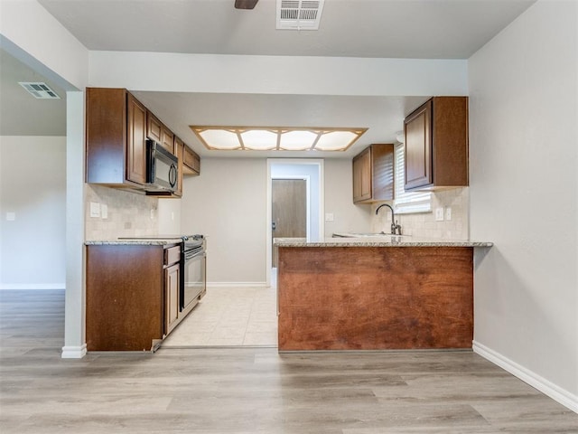720 Cottonwood Dr, Moore, OK 73160 - kitchen featuring black appliances, a sink, baseboards, and backsplash