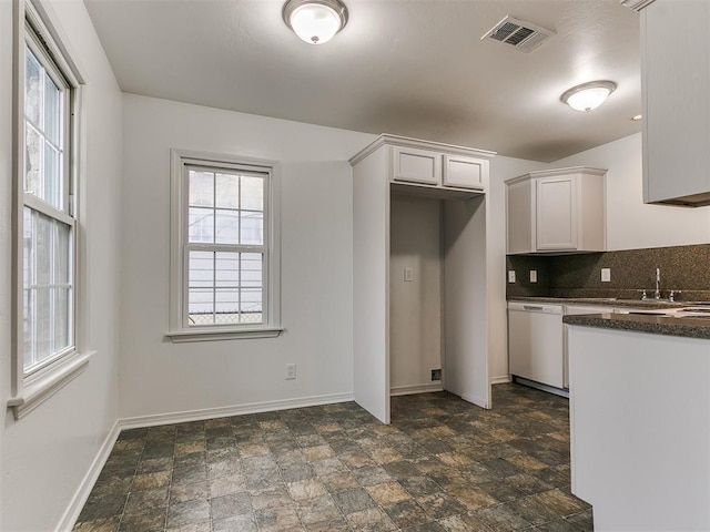 kitchen featuring a healthy amount of sunlight, dishwasher, decorative backsplash, and white cabinets