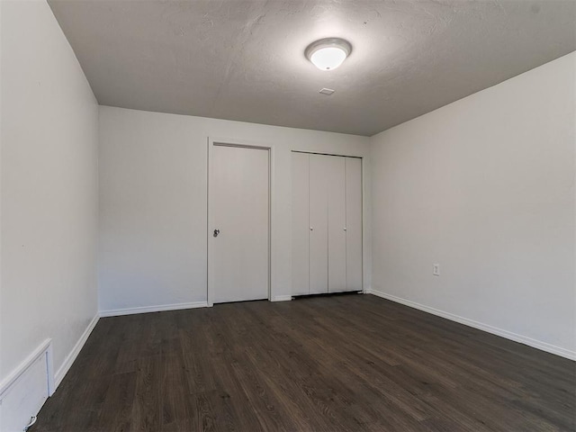 unfurnished bedroom with dark hardwood / wood-style floors