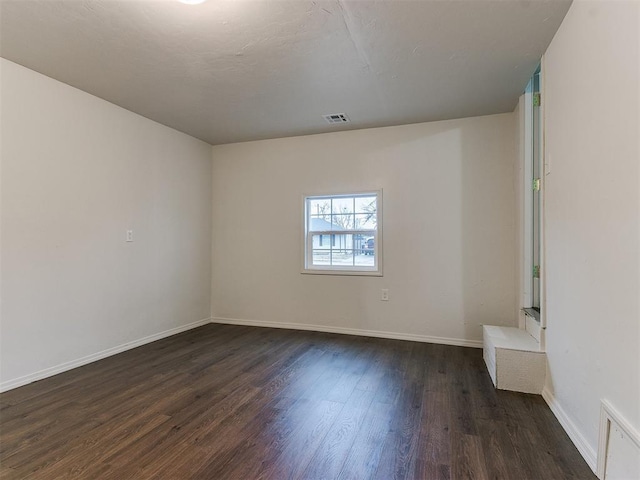 empty room with dark hardwood / wood-style flooring