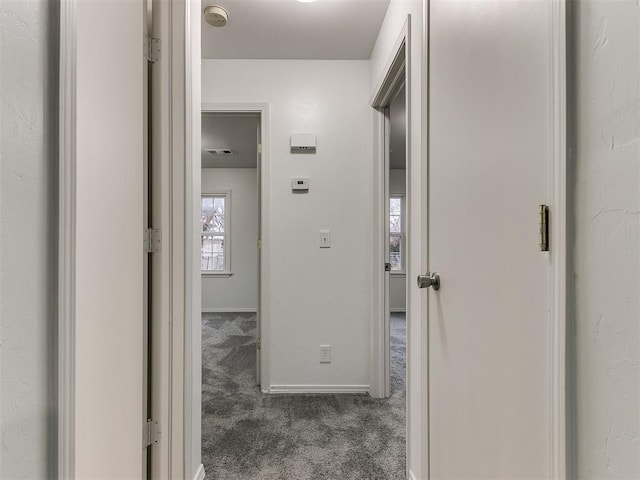 hallway featuring dark colored carpet