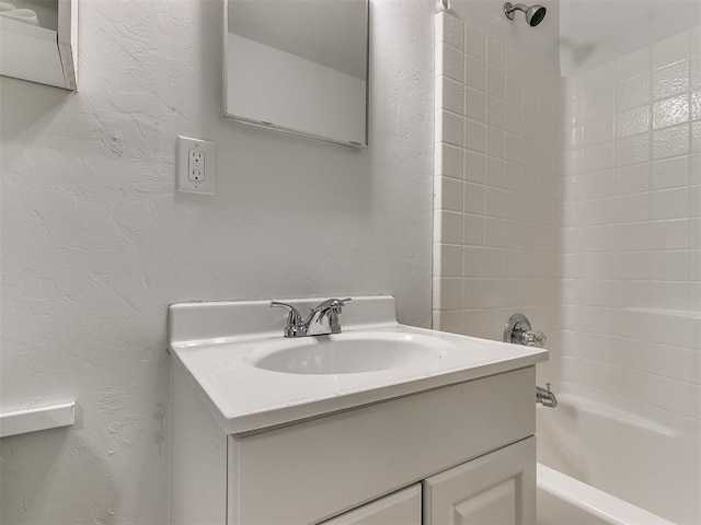 bathroom featuring tiled shower / bath combo and vanity