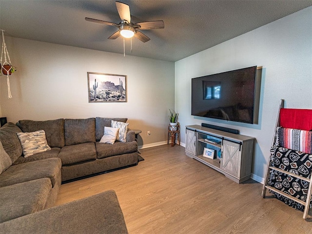 living room featuring a textured ceiling, light hardwood / wood-style flooring, and ceiling fan