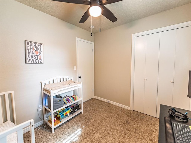 bedroom with ceiling fan, carpet flooring, a closet, and a textured ceiling