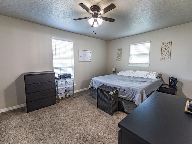 carpeted bedroom featuring ceiling fan and a textured ceiling