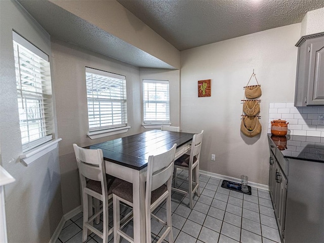 tiled dining room featuring a textured ceiling