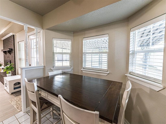 dining area with a textured ceiling and light tile patterned floors