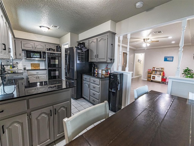 kitchen featuring gray cabinets, ceiling fan, tasteful backsplash, black appliances, and ornate columns