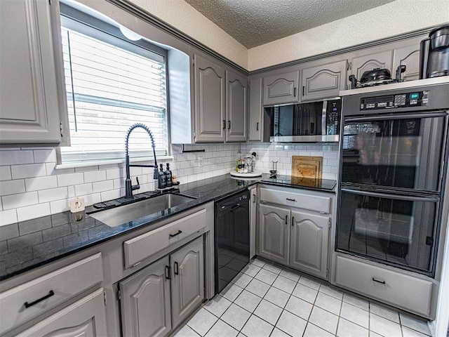 kitchen with sink, gray cabinets, black appliances, a textured ceiling, and light tile patterned flooring