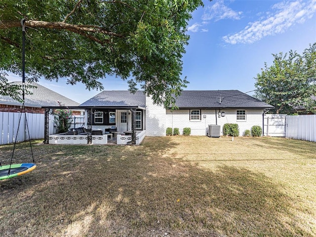 rear view of property with a trampoline, central AC, a patio, and a lawn