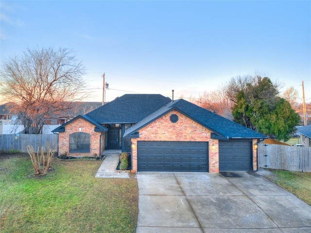 ranch-style house with a garage and a yard