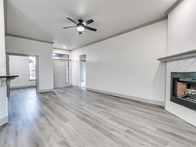 unfurnished living room featuring ornamental molding, ceiling fan, and light hardwood / wood-style floors