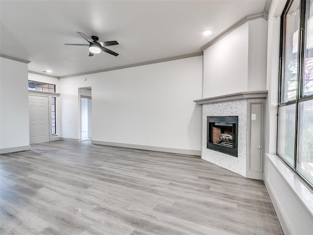 unfurnished living room with crown molding, ceiling fan, and light wood-type flooring