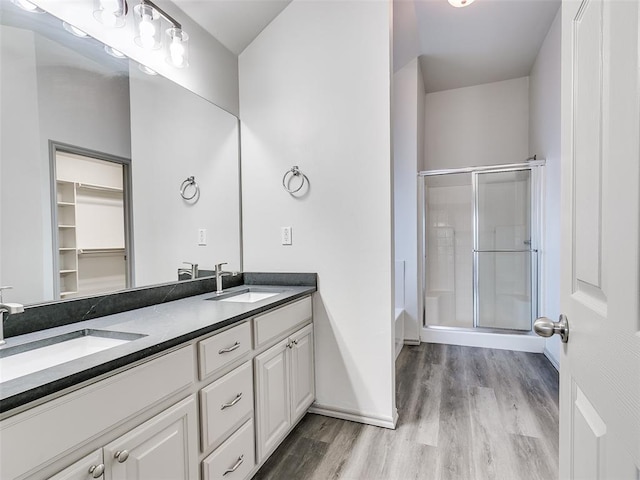 bathroom featuring vanity, wood-type flooring, and plus walk in shower