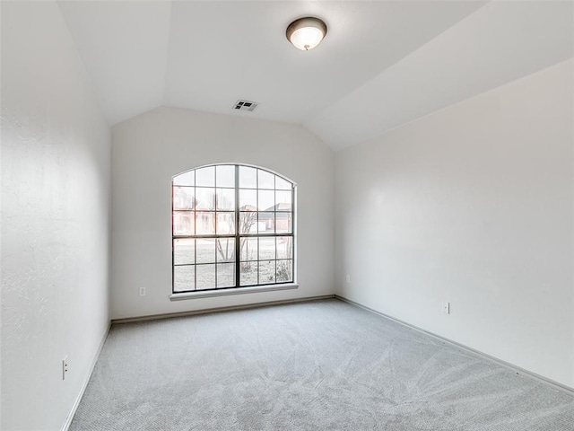 empty room with vaulted ceiling and light carpet