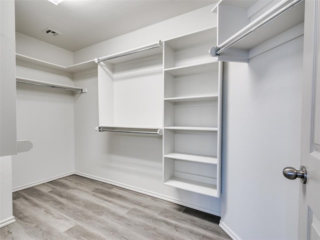 walk in closet with light wood-type flooring