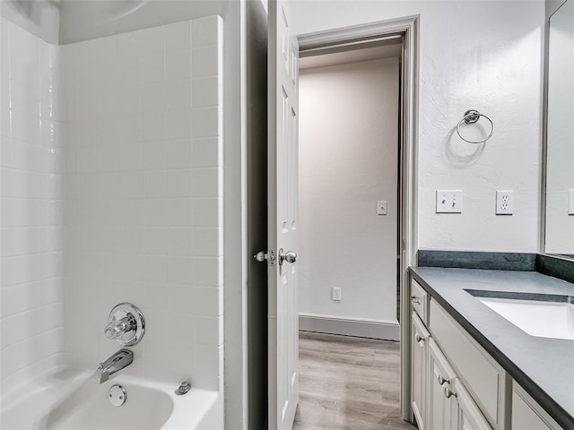 bathroom with hardwood / wood-style flooring, shower / washtub combination, and vanity