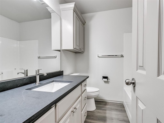 full bathroom featuring hardwood / wood-style flooring, vanity, bathing tub / shower combination, and toilet