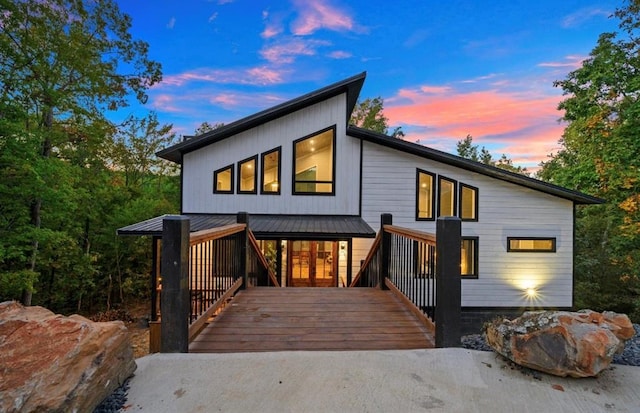 back house at dusk featuring a deck