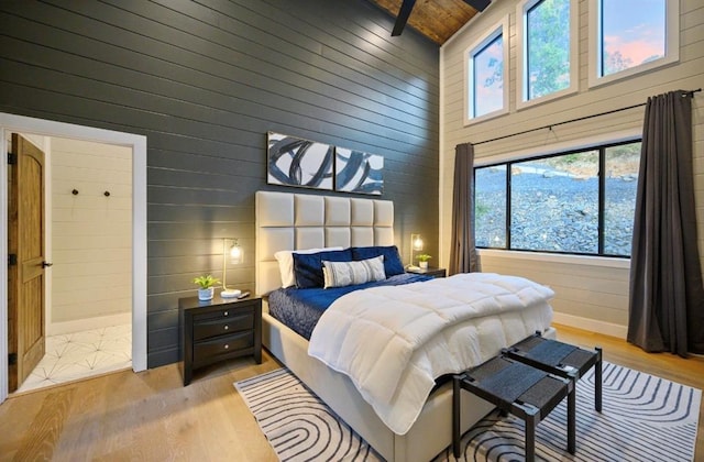 bedroom featuring wood ceiling, wood walls, beam ceiling, and light wood-type flooring