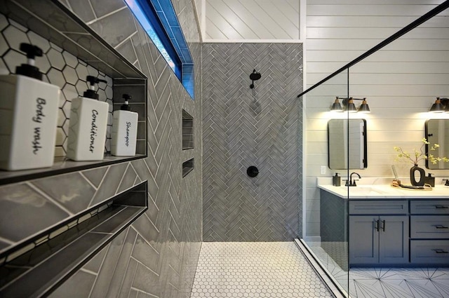 bathroom with vanity, a tile shower, and tile patterned floors