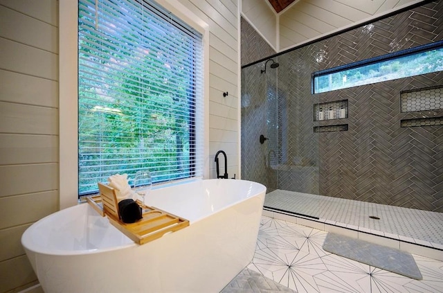 bathroom featuring shower with separate bathtub