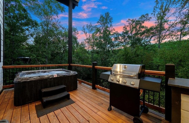 deck at dusk featuring a hot tub and grilling area