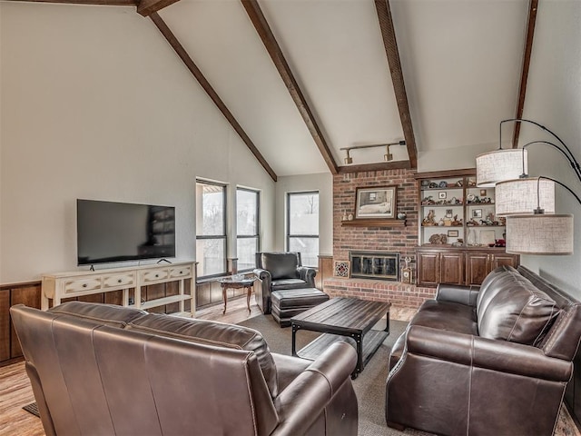 living room with beamed ceiling, high vaulted ceiling, and a brick fireplace