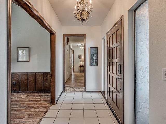 hallway featuring light tile patterned floors and a notable chandelier