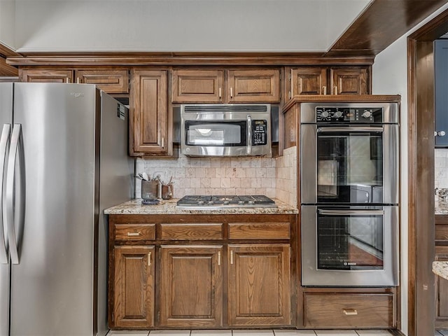 kitchen with decorative backsplash and appliances with stainless steel finishes