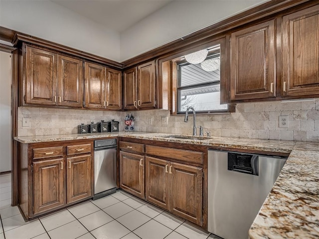 kitchen with tasteful backsplash, sink, stainless steel dishwasher, and light stone counters