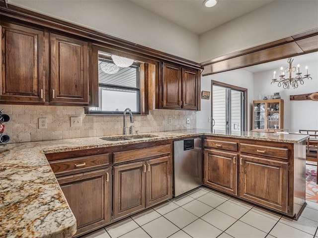 kitchen featuring pendant lighting, sink, dishwasher, backsplash, and kitchen peninsula