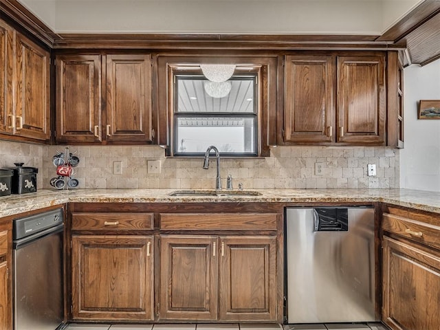 kitchen with tasteful backsplash, stainless steel dishwasher, light stone countertops, and sink