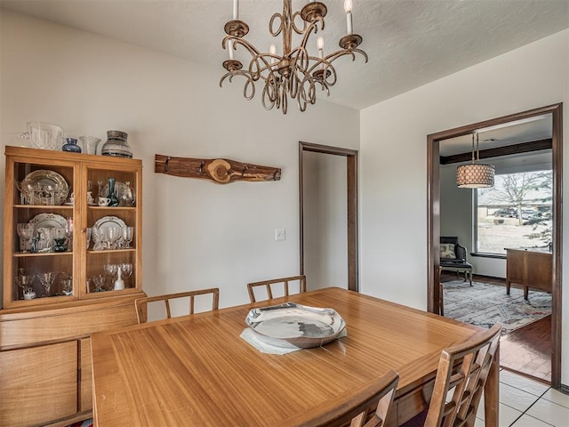 dining area featuring an inviting chandelier and light tile patterned floors