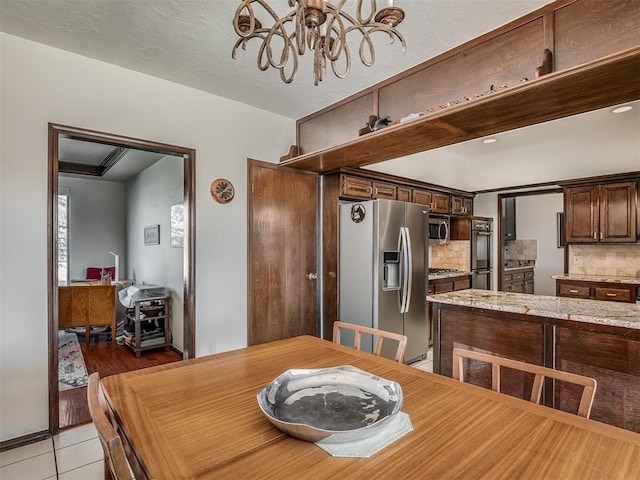 dining area featuring light tile patterned floors and a notable chandelier