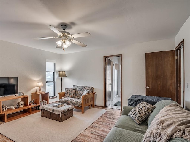 living room with ceiling fan and light hardwood / wood-style flooring