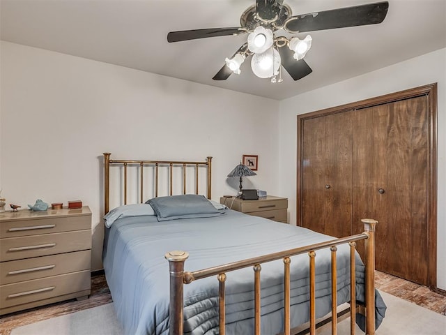 bedroom with light hardwood / wood-style flooring, a closet, and ceiling fan