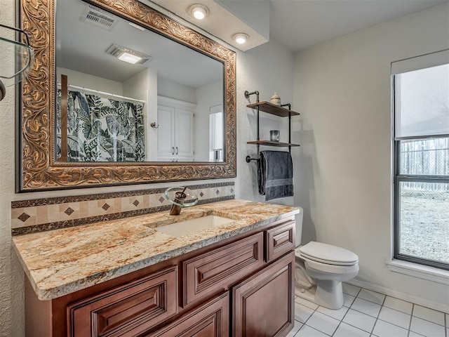 bathroom featuring vanity, a healthy amount of sunlight, backsplash, and tile patterned floors