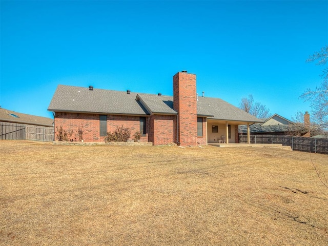 back of property with a yard and a patio