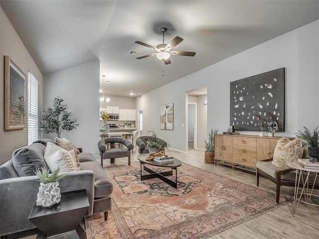 living room featuring ceiling fan, lofted ceiling, a wealth of natural light, and light wood-type flooring