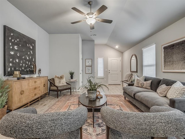 living room featuring ceiling fan, vaulted ceiling, and light hardwood / wood-style flooring