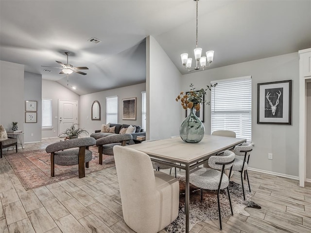 dining space with lofted ceiling and ceiling fan with notable chandelier