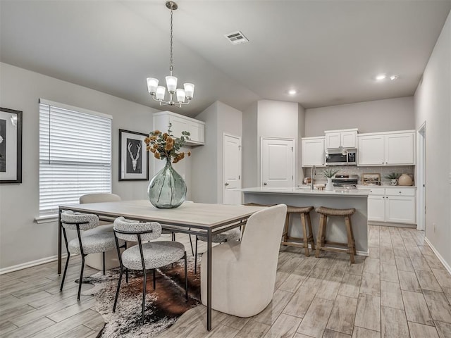 dining space with vaulted ceiling and a chandelier